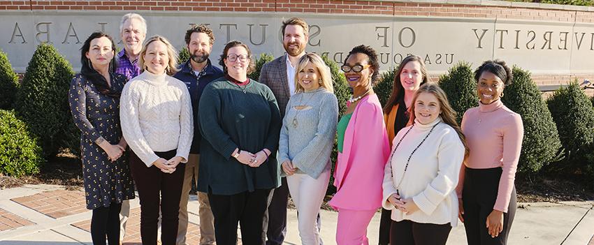 Group picture of Counseling and Testing staff outside in front of USA Sign.